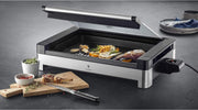 Parrilla de mesa eléctrica WMF Lono con tapa de cristal, placa de grill revestida, bandeja de goteo extraíble, apta para lavavajillas, acero inoxidable mate, 2200 vatios