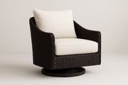 Sillón giratorio de resina trenzada marrón con cojines color crema