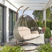 LeisureMod Silla Colgante Huevo para 2 Personas con Soporte - Columpio Hamaca Lounger de Ratán para Patio Exterior/Interior con Cojines